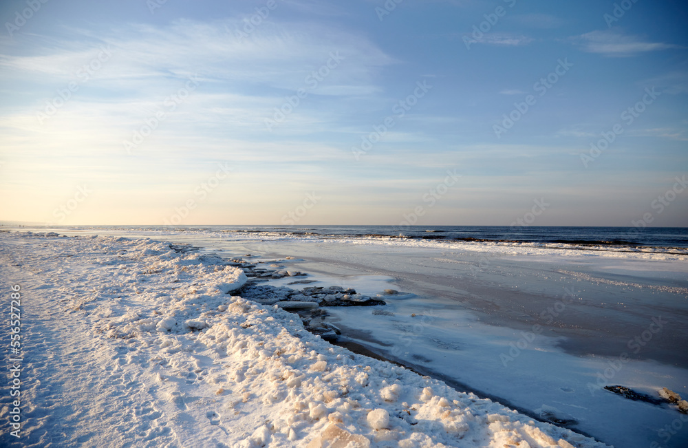 Winter landscape with icy sea coast and calm blue sky, selective focus