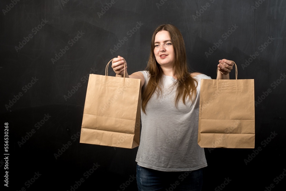 a woman of European appearance holds two kraft bags in her hands. Shopping a woman of European appearance holds two kraft bags in her hands. Shopping