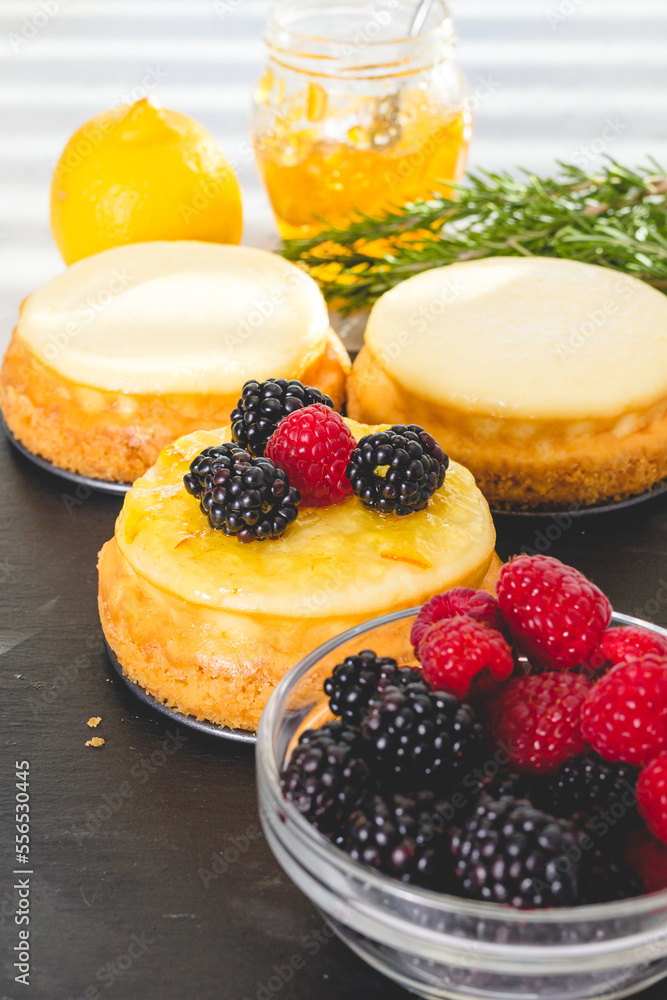 Cheesecakes with berries. Decorating mini cheesecakes with orange marmalade and fresh raspberries and blackberries Cheesecakes with berries. Decorating mini cheesecakes with orange marmalade and fresh raspberries and blackberries