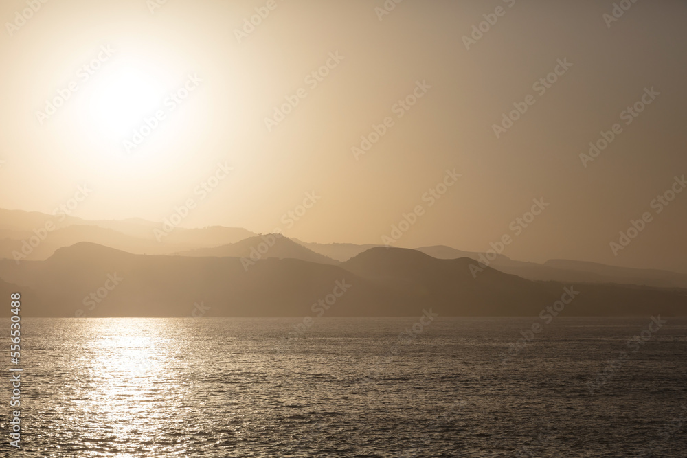 View to mountains in hazy atmosphere against the sun