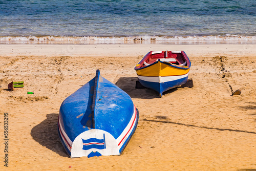 Two boats in the Atlantic sandy beach of Tarrafal, Santiago Island, Cape Verde Islands photo