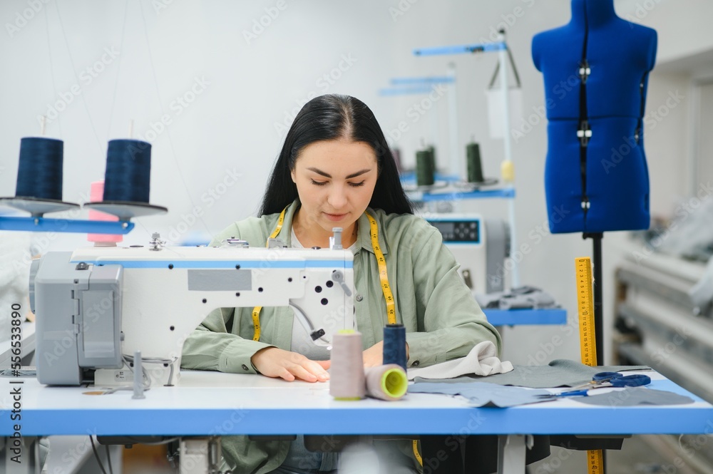 Young woman working as seamstress in clothing factory. Young woman working as seamstress in clothing factory.