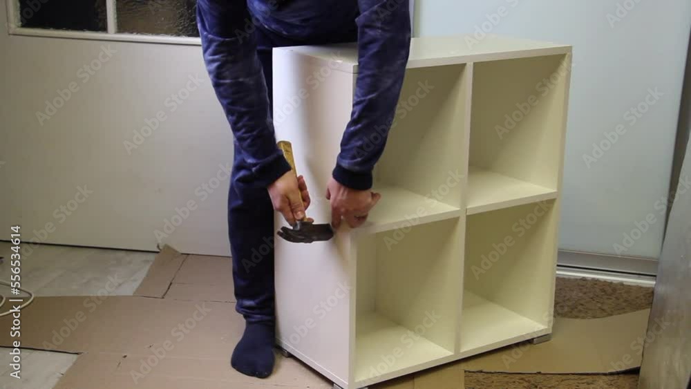 A man installs plugs on euro screws. Demonstrates assembled modular