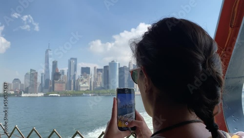 Young woman taking picture with smartphone staten island ferry magnificent views of skyscrapers in manhattan new york buildings seen from the river concept lifestyle city vacation adventu