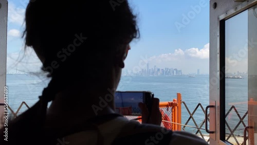 Young woman taking picture with smartphone staten island ferry magnificent views of skyscrapers in manhattan new york buildings seen from the river concept lifestyle city vacation adventure