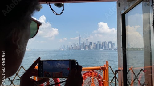 Young woman taking picture with smartphone staten island ferry magnificent views of skyscrapers in manhattan new york buildings seen from the river concept lifestyle city vacation adventure