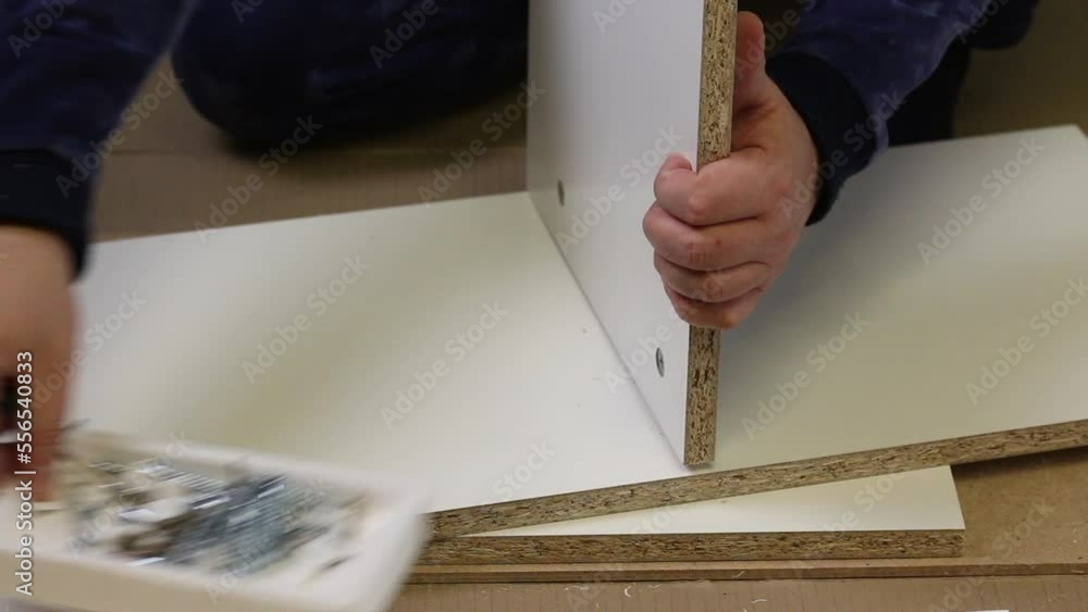 Wooden modular rack. Assembling a modular rack. A man installs a wooden ...