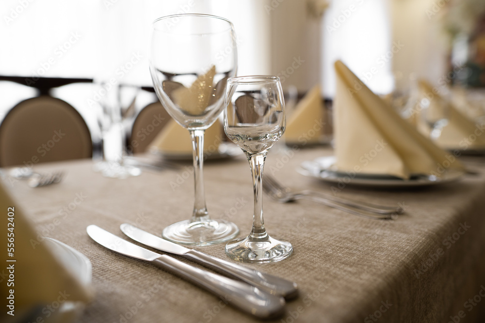 empty goblets and other cutlery are served on the festive table. empty goblets and other cutlery are served on the festive table.