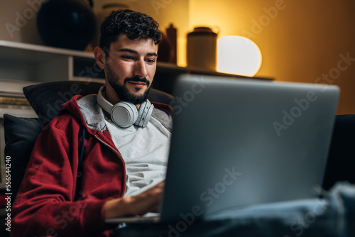 Young caucasian man works form home at night photo