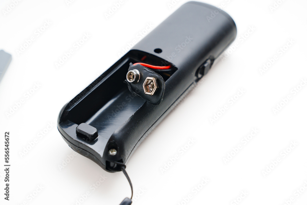 Ultrasonic dog repeller open without batteries on a white background. Ultrasonic dog repeller open without batteries on a white background.