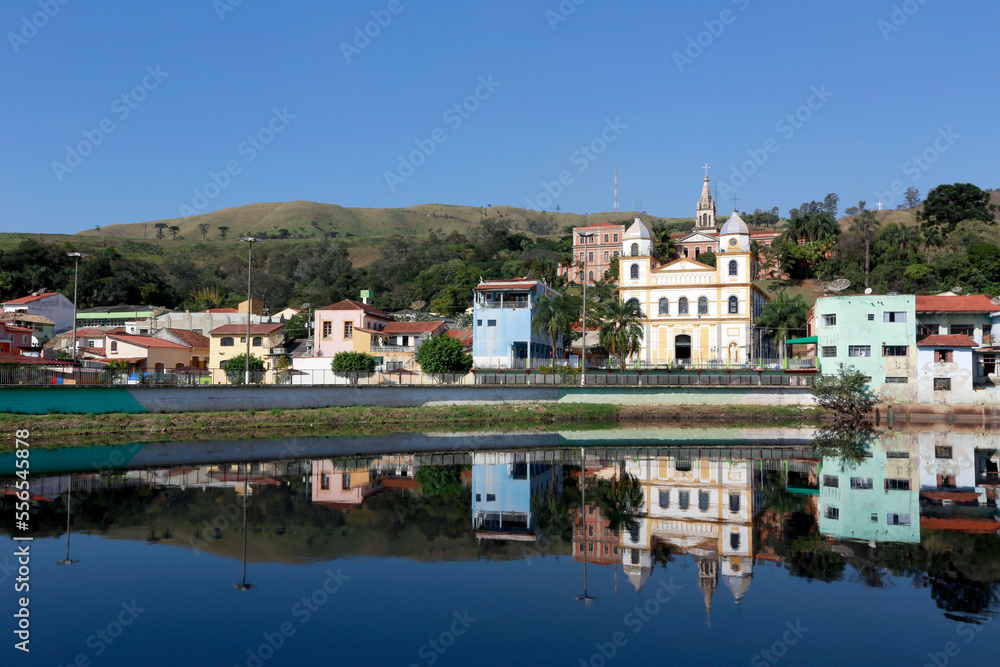 Sanctuary and houses in Pirapora do Bom Jesus reflect in the calm waters of the Tiete River. Sao Paulo State, Brazil