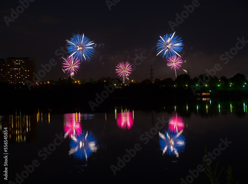 Beautiful blue and red fireworks with reflection in the pond photo