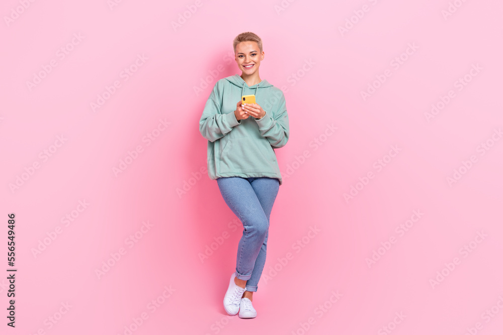Full length photo of adorable pretty lady use quality device promoting novelty empty space isolated on pink color background Full length photo of adorable pretty lady use quality device promoting novelty empty space isolated on pink color background