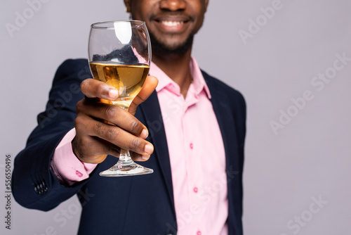 young black man raises a glass of wine with a smile