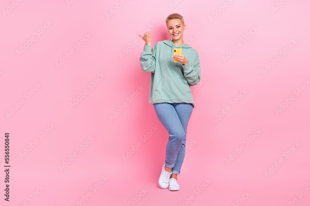 Full length photo of positive lady addicted user presenting modern device empty space sale discount isolated on pink color background Full length photo of positive lady addicted user presenting modern device empty space sale discount isolated on pink color background