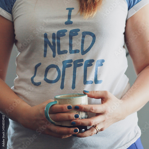 Fotografia person wearing shirt that says I need coffee while holding a cup of coffee