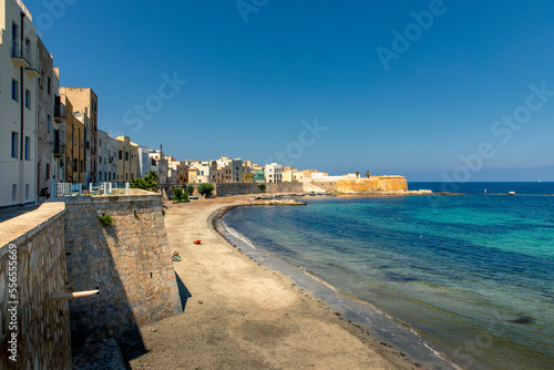 Trapani, Sicily, Italy - July 10, 2020: Rocky beach and fortress on the beach of Mura di Tramontana, north of the old town centre of Trapani, Sicily