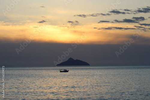sunset with the vie of a small boat in the ocean near the island Paximadia in Greece 