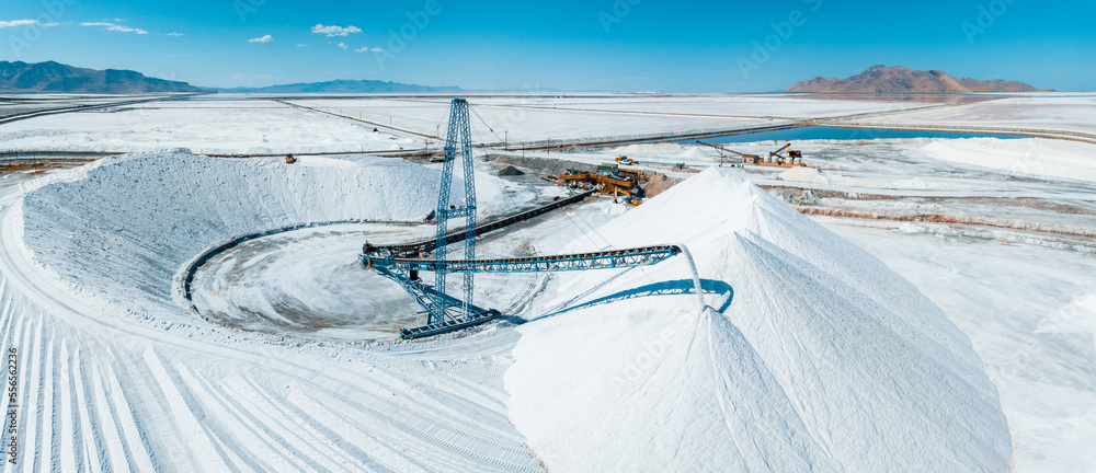 Salt Lake City, Utah landscape with desert salt mining factory at lake Bonneville with piles of white mineral and industrial equipment