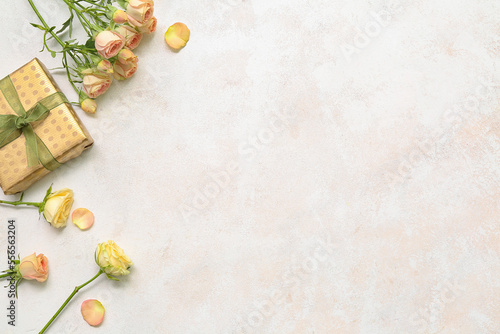Composition with beautiful rose flowers and gift box on light background