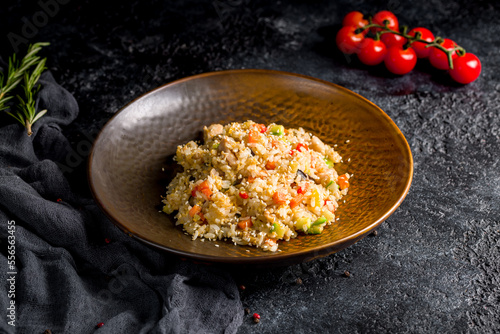 Fried rice with chicken and vegetables on dark stone table