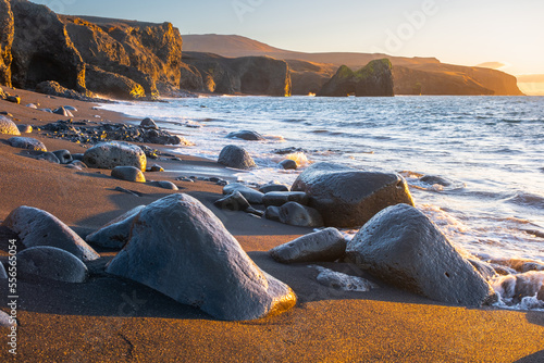 Scenic Beach with Black Sand by Low Tide at Sunset near Kopasker village, Volcanic coastline in Iceland photo