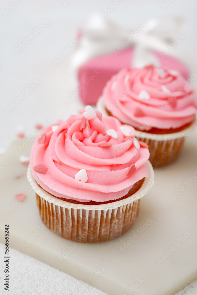 Board with tasty cupcakes for Valentine's Day on white background, closeup Board with tasty cupcakes for Valentine's Day on white background, closeup