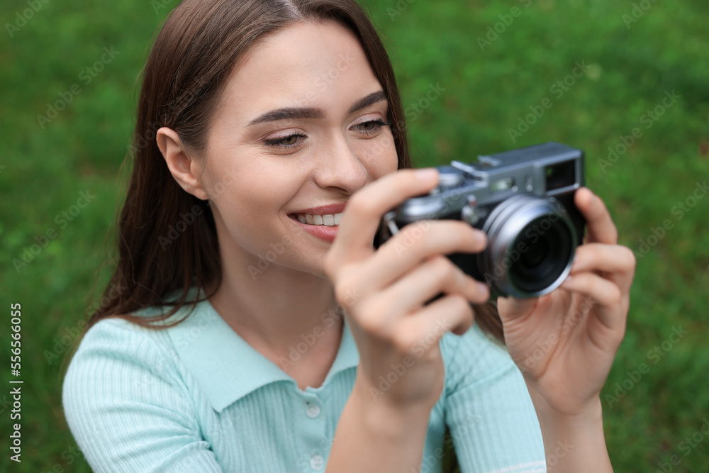 Young woman with camera taking photo outdoors. Interesting hobby Young woman with camera taking photo outdoors. Interesting hobby