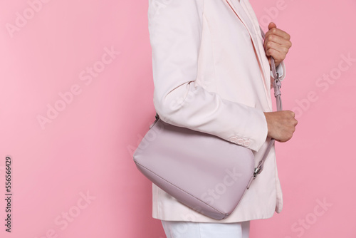 Woman with stylish bag on pink background, closeup. Space for text