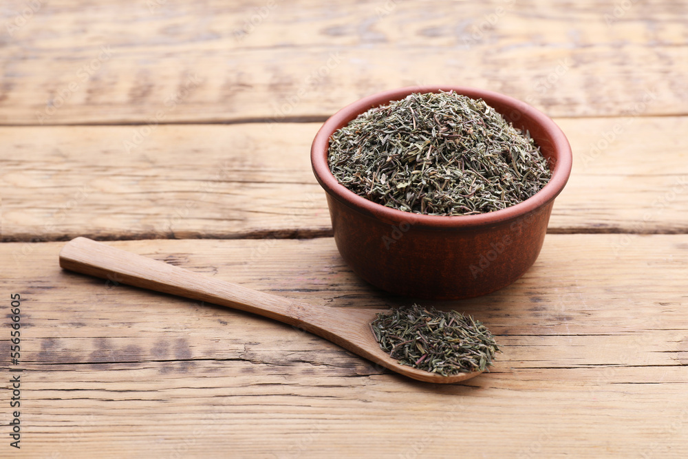 Bowl and spoon with dried thyme on wooden table Bowl and spoon with dried thyme on wooden table