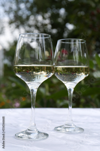 Glasses of white wine served on marble table outdoors