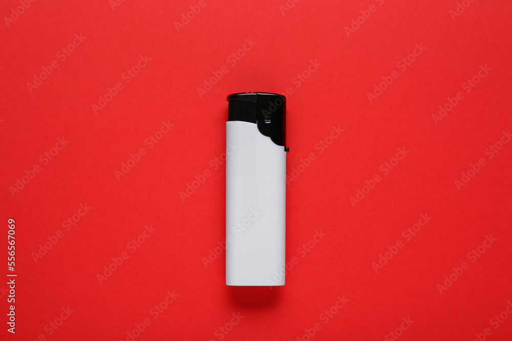 Stylish small pocket lighter on red background, top view Stylish small pocket lighter on red background, top view
