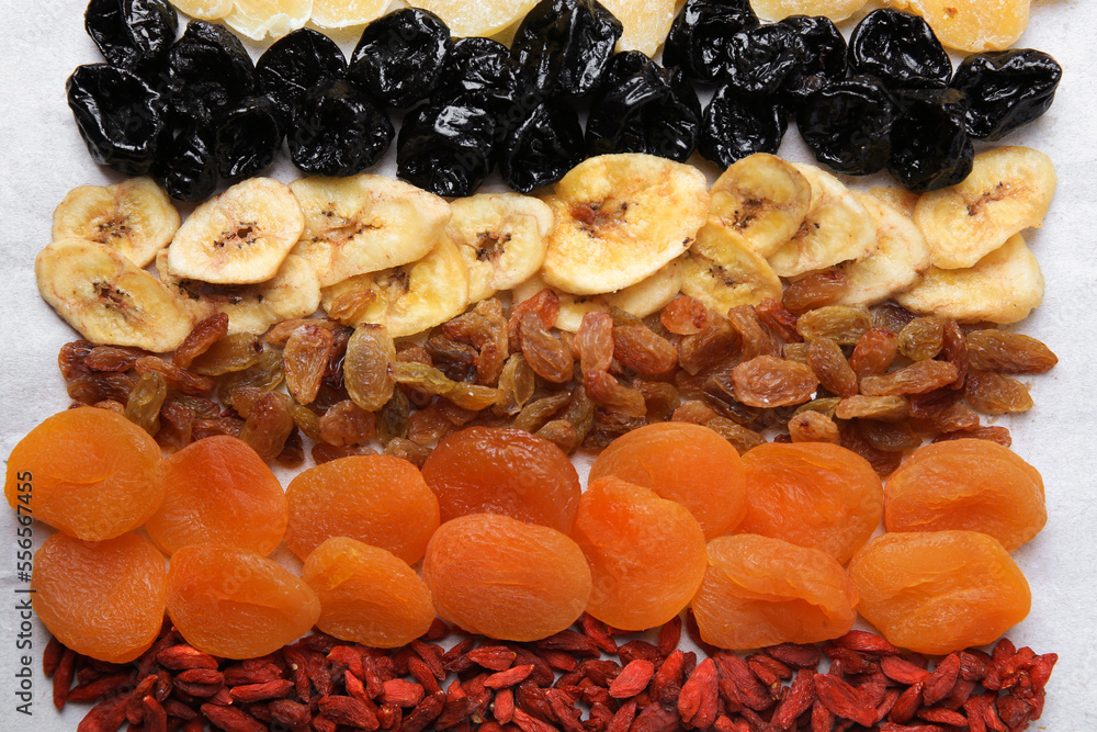 Different tasty dried fruits on paper, flat lay Different tasty dried fruits on paper, flat lay