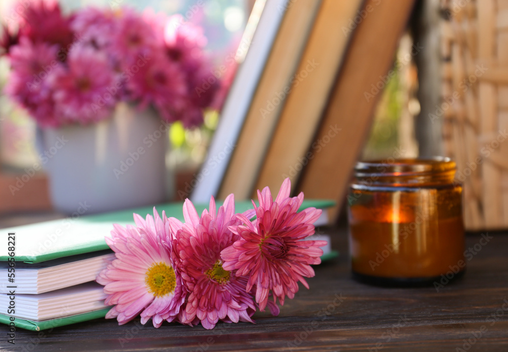 Book with beautiful chrysanthemum flowers as bookmark on wooden table, closeup Book with beautiful chrysanthemum flowers as bookmark on wooden table, closeup