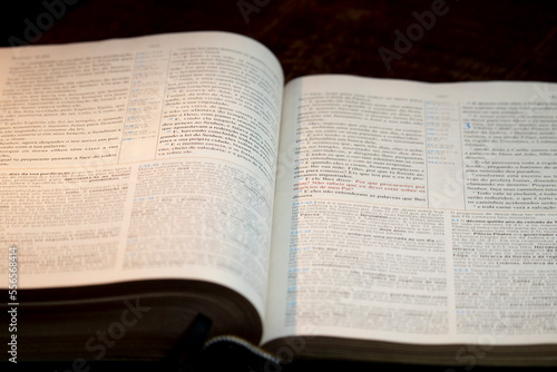 Holy bible open on a wooden table with a bookmark in the middle of the book