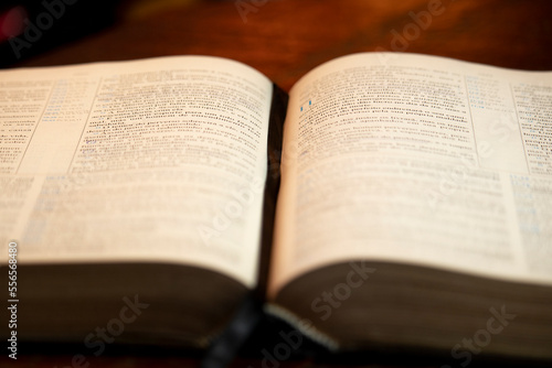 Holy Bible open on wooden table with page marker