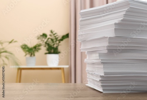 Stack of paper sheets on wooden table indoors. Space for text