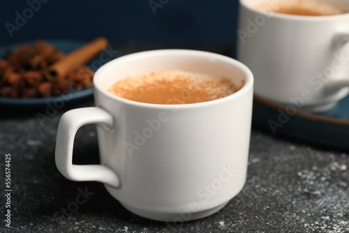 Delicious eggnog with anise and cinnamon on grey table
