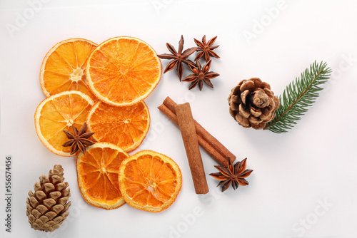 Flat lay composition with dry orange slices, anise stars and cinnamon sticks on white background