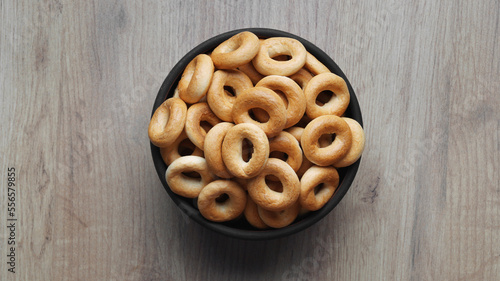 Bowl of tasty dry bagels (sushki) on wooden table, top view