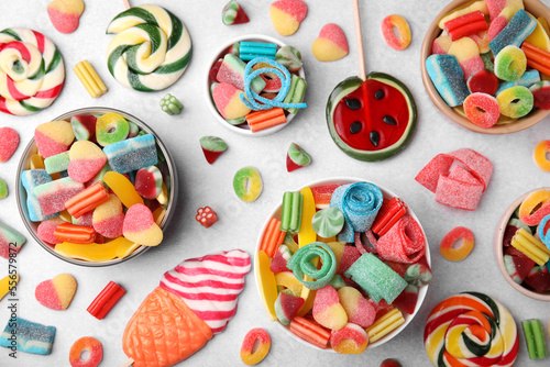 Many tasty colorful jelly candies on white table, flat lay