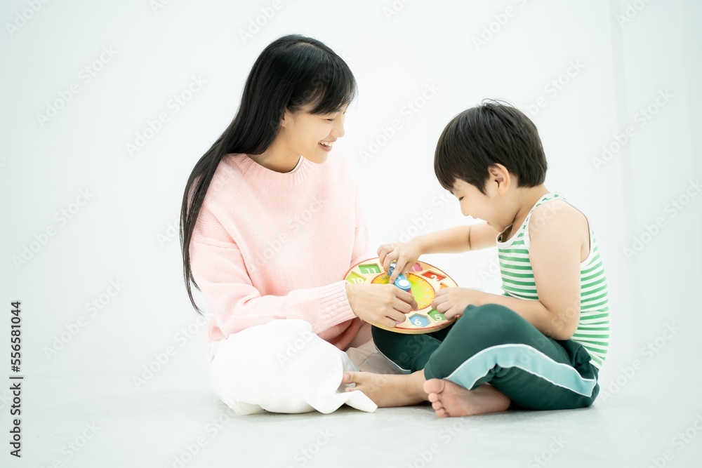 Asian mother and son schoolboy studying time, minutes and hours. Home schooling, home learning concept. Asian mother and son schoolboy studying time, minutes and hours. Home schooling, home learning concept.