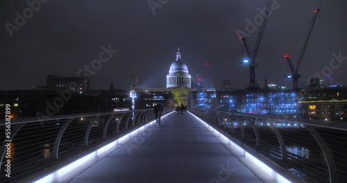 People Walking On London Millennium Bridge At Night. St. Paul's Cathedral In Backdrop. wide, POV photo