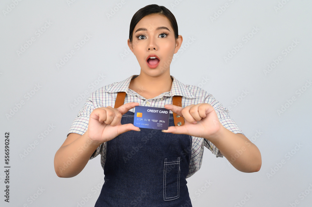 Portrait of young asian woman in waitress uniform pose with credit card Portrait of young asian woman in waitress uniform pose with credit card