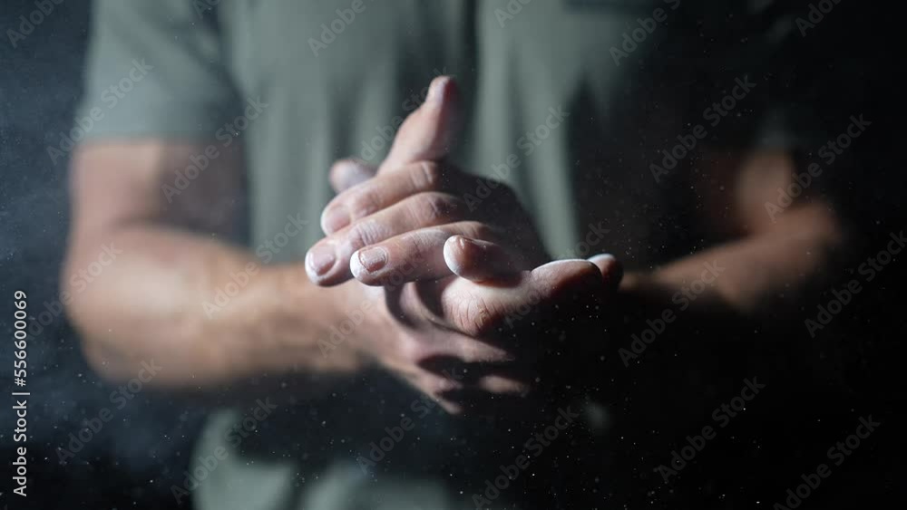 Male athlete clapping hands strongly with magnesium carbonate chalk, Close up slow motion shot