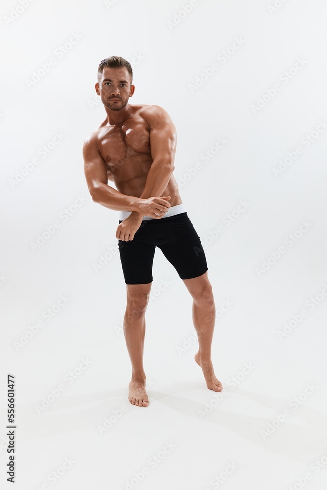 Man athletic body bodybuilder in briefs with naked torso abs full-length in the background, fitness classes. Advertising, sports, active lifestyle, competition, challenge concept.