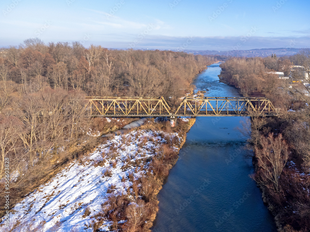 Aerial view. Old railroad bridge. Urban landscape. Winter, river, water, trees, nature, snow.