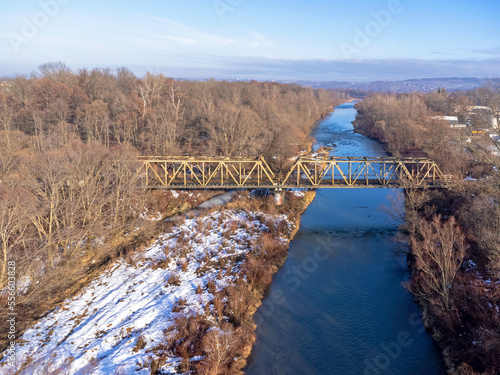 Obraz na płótnie Aerial view. Old railroad bridge. Urban landscape. Winter, river, water, trees, nature, snow. w salonie