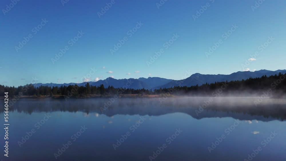 Lake mist with mountains and forest Enid British Columbia Canada Lake mist with mountains and forest Enid British Columbia Canada