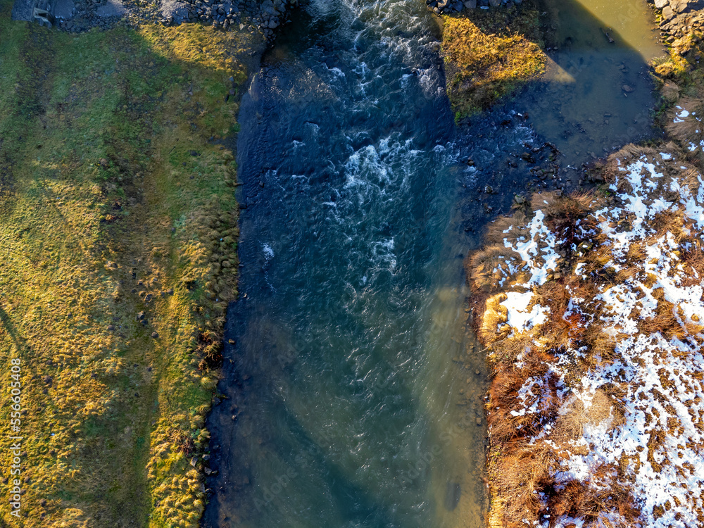 Aerial view. Flowing river, nature, winter, snow, meadow.
